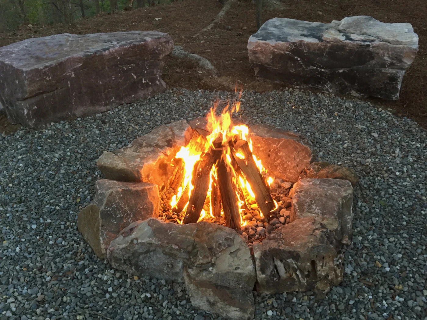 Round stone fire pit on a gravel patio