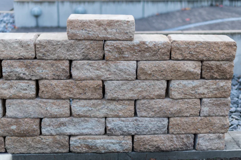 Segmental stone block retaining wall with a cap row