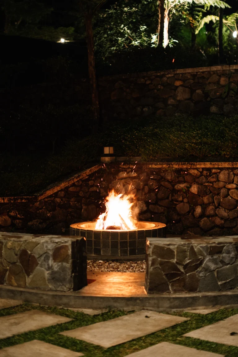 Stone fire pit glowing at night in a backyard
